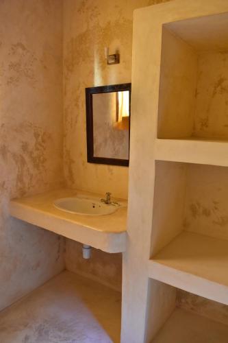 een badkamer met een wastafel en een spiegel bij Amu House in Lamu