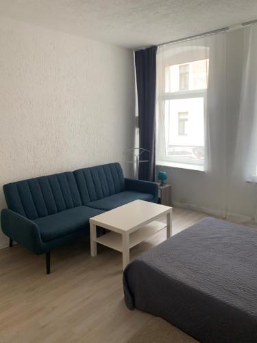 a living room with a blue couch and a table at Am Bahnhof in Zwickau