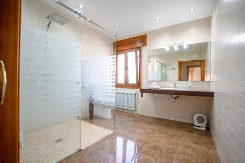 Un baño con ducha de cristal y lavabo. en Casa Palau, en Morella