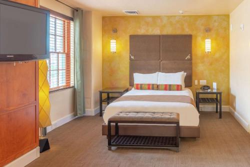 a bedroom with a large bed and a flat screen tv at Hotel Andaluz Albuquerque, Curio Collection By Hilton in Albuquerque