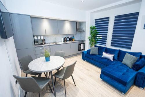 a living room with a blue couch and a table at Comfort on Market St l 1BR 1BA l Gem in Watford in Watford