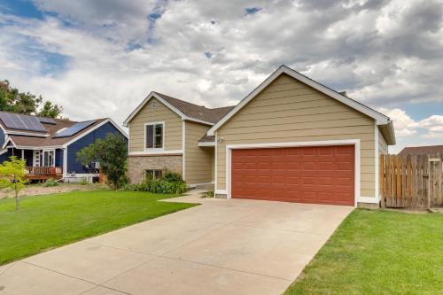a house with a red garage in a yard at 11 Mi to Denver Pet-Friendly Home in Thornton! in Thornton
