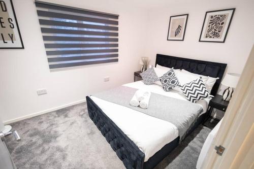 a bedroom with a black and white bed and a window at Comfort on Market St l 1BR 1BA l Gem in Watford in Watford
