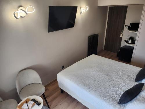 a bedroom with a bed and a tv on the wall at Villa Pona in Digoin