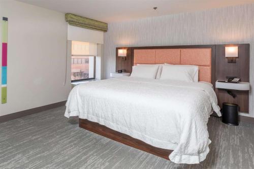 a large bedroom with a large bed with white sheets at Hampton Inn Williamsport in Williamsport