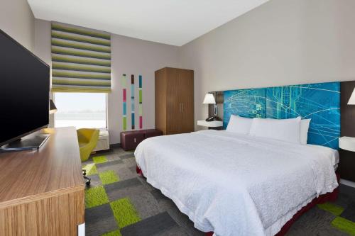 ein Hotelzimmer mit einem Bett und einem Flachbildfernseher in der Unterkunft Hampton Inn Marysville in Marysville