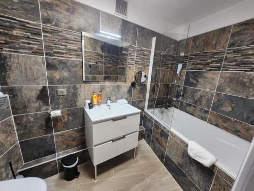 een badkamer met een wastafel, een bad en een toilet bij Villa Pona in Digoin