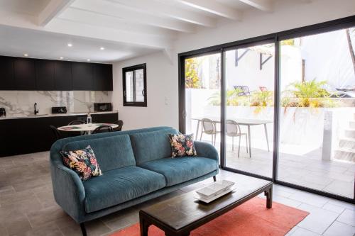 a living room with a blue couch and a table at Domaine de la Palmeraie - Villas Lodge in Le Diamant