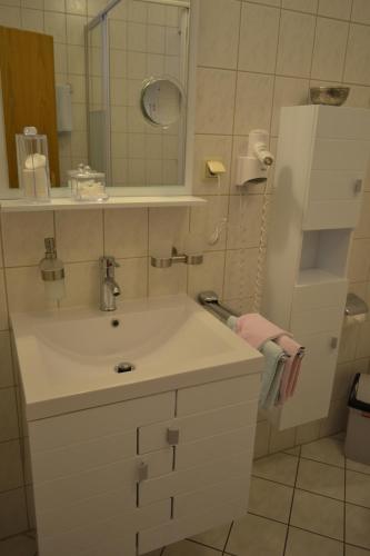 a bathroom with a white sink and a mirror at Hotel & Restaurant Zur Linde in Freital