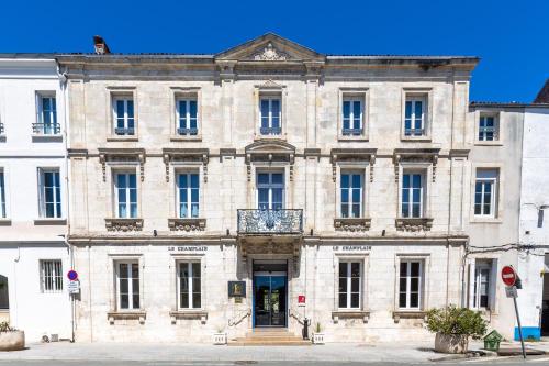 un gran edificio de piedra con una puerta grande en Le Champlain en La Rochelle