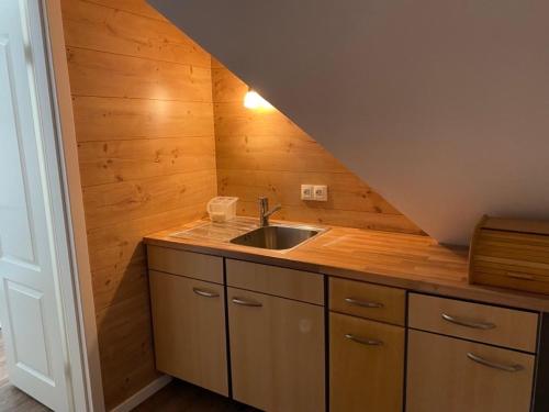 a small kitchen with a sink and a staircase at 1Zi Ferienwohnung bis zu 3 Personen für Dienstreisende in Loßburg Schwarzwald in Loßburg