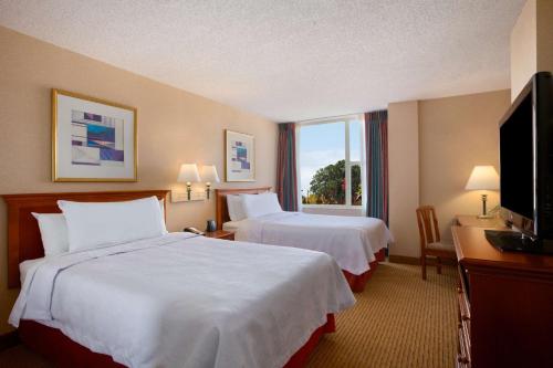 a hotel room with two beds and a television at Homewood Suites by Hilton Falls Church in Merrifield