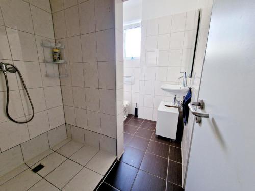 een badkamer met een douche en een wastafel bij iBO-APART Ganze Ferienwohnung in Herzogenaurach in Herzogenaurach