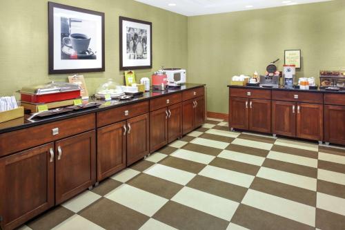 een keuken met houten kasten en een geruite vloer bij Hampton Inn Portage in Portage