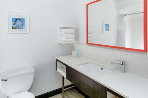 a bathroom with a toilet and a sink with a mirror at Hampton Inn Portage in Portage