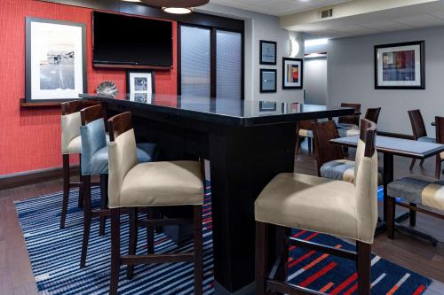 a bar in a room with chairs and a tv at Hampton Inn Columbia in Columbia