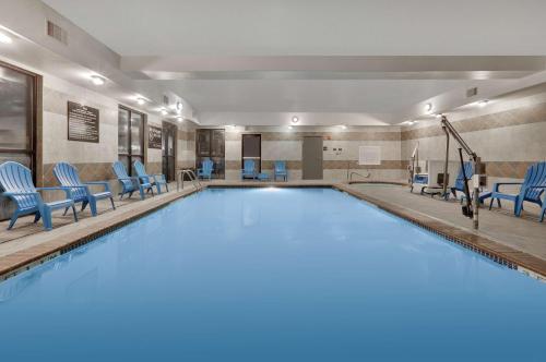 柴爾德里斯的住宿－柴德里斯漢普頓套房酒店，一个带蓝色椅子的大型游泳池