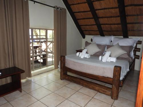 a bedroom with a bed with white pillows on it at African Kruger Lodge in Marloth Park