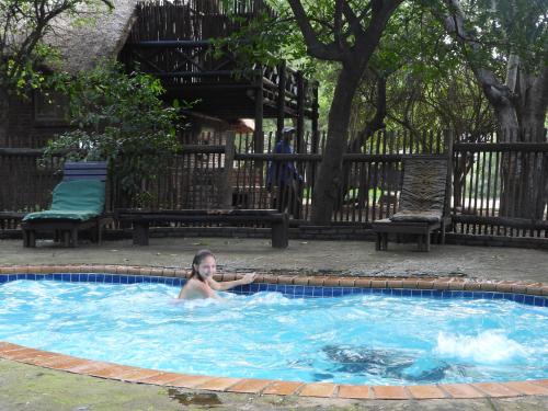 a young child swimming in a swimming pool at African Kruger Lodge in Marloth Park