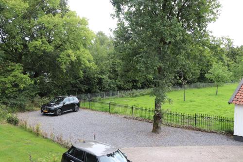a black car parked in a driveway next to a fence at WijkD in Leende