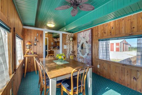 a dining room with a table and chairs and a ceiling fan at Charming Converted Railcar Studio in Joplin! in Joplin