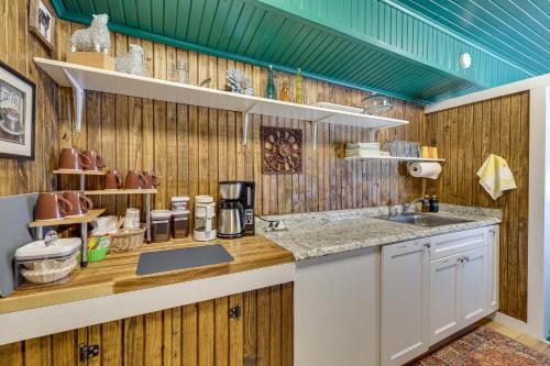 a kitchen with wooden walls and a sink and a counter at Charming Converted Railcar Studio in Joplin! in Joplin