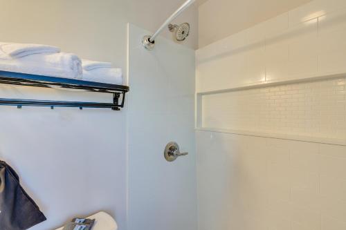 a white bathroom with a shower and a shower at Charming Converted Railcar Studio in Joplin! in Joplin