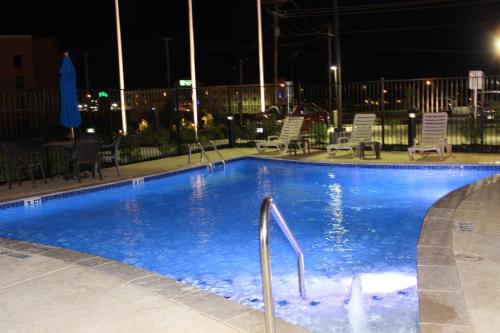 - une piscine avec des chaises et des lumières la nuit dans l'établissement Hampton Inn Cotulla, à Cotulla