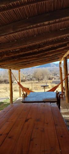 a wooden deck with a hammock in a pavilion at Cabañitas EL REPOSO HUMAHUACA in Humahuaca