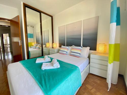 a bedroom with a large bed with towels on it at Quarteira Beach Apartment by Homing in Quarteira