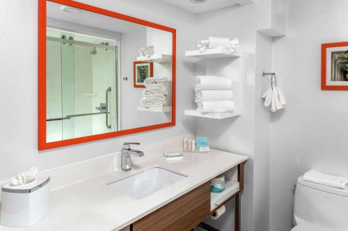 a bathroom with a sink and a mirror and a toilet at Hampton Inn Miami/Dadeland in South Miami