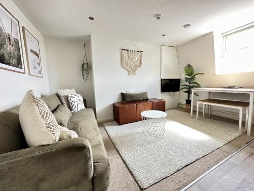 a living room with a couch and a piano at Central City Beach Pad in Brighton & Hove