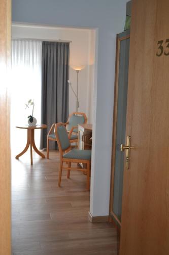 a room with a table and chairs and a dining room at Hotel & Restaurant Zur Linde in Freital