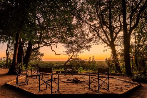 a group of chairs sitting in the dirt under trees at ASKIESBOS - Samochima Bush Camp in Shakawe