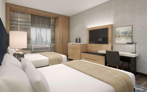 Habitación de hotel con 2 camas y escritorio en Doubletree By Hilton West Kelowna, en West Kelowna