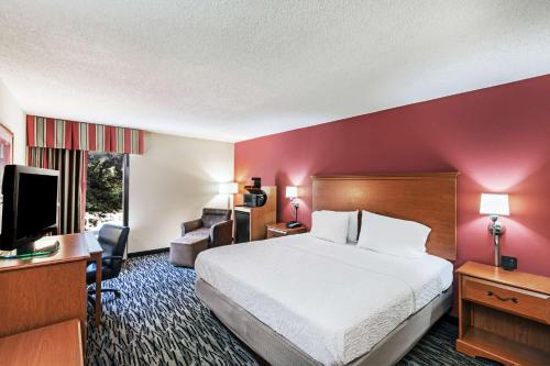 a hotel room with a bed and a flat screen tv at Hampton Inn Aiken in Aiken