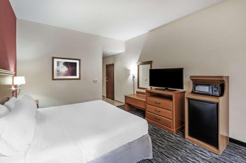 a hotel room with a bed and a flat screen tv at Hampton Inn Aiken in Aiken