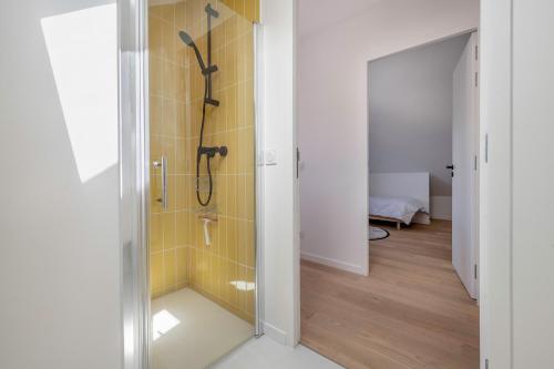 a bathroom with a shower with yellow tiles at Maison moderne avec jardin pour 8 à La Baule in La Baule