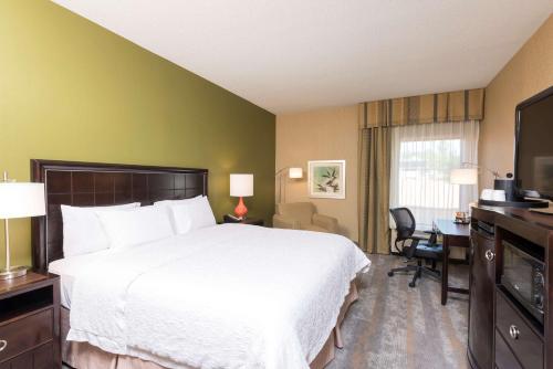 a hotel room with a large bed and a desk at Hampton Inn Port Huron in Port Huron