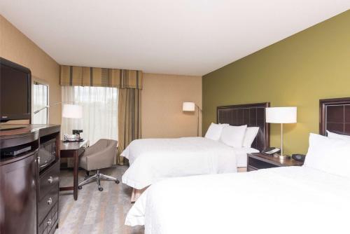 a hotel room with two beds and a flat screen tv at Hampton Inn Port Huron in Port Huron