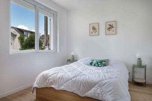 a white bedroom with a bed and a window at Maison moderne avec jardin pour 8 à La Baule in La Baule