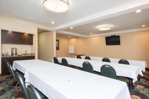 a conference room with white tables and chairs and a flat screen tv at Hampton Inn Port Huron in Port Huron
