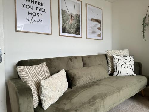 a couch in a living room with pictures on the wall at Central City Beach Pad in Brighton & Hove