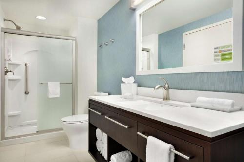a bathroom with a sink and a toilet and a mirror at Home2 Suites by Hilton Middletown in Middletown