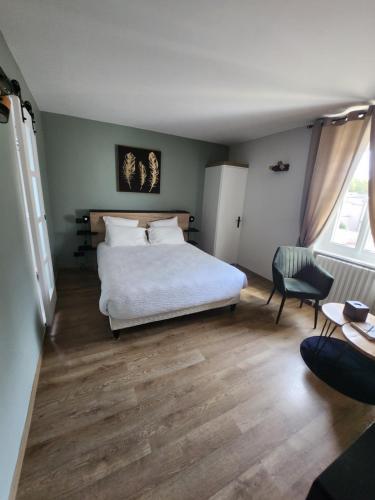 een slaapkamer met een wit bed en een stoel bij Villa Pona in Digoin