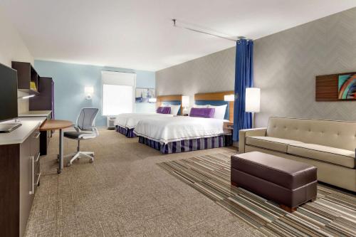 ミドルタウンにあるHome2 Suites by Hilton Middletownのベッドとデスクが備わるホテルルームです。