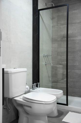 a bathroom with a toilet and a glass shower at ANDÉN by FMA Coliving in Salta