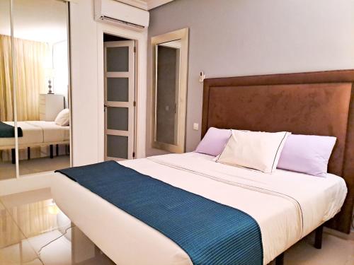 a bedroom with a large bed with a blue blanket at Modern Townhouse Ocean Front in Adeje