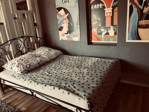 łóżko w pokoju z plakatami na ścianie w obiekcie Bubinga w mieście Kruševac