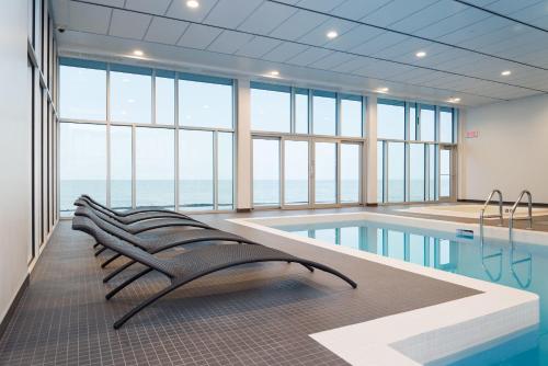 a swimming pool with a row of benches in a building at Riotel Matane in Matane